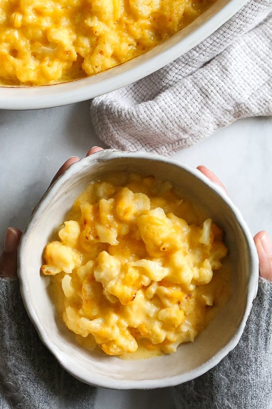 Cheesy Baked Cauliflower "Mac" and Cheese is perfect when you're craving macaroni and cheese–without the pasta! It's lower in carbs and each bowl has a healthy amount of vegetables and protein!