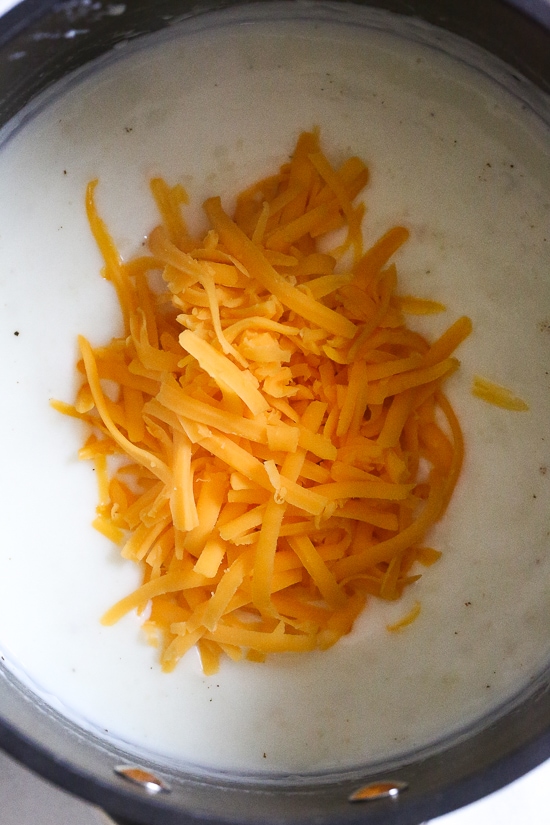 Cheesy Baked Cauliflower "Mac" and Cheese is perfect when you're craving macaroni and cheese–without the pasta! It's lower in carbs and each bowl has a healthy amount of vegetables and protein! making a cheese sauce that starts with a white sauce