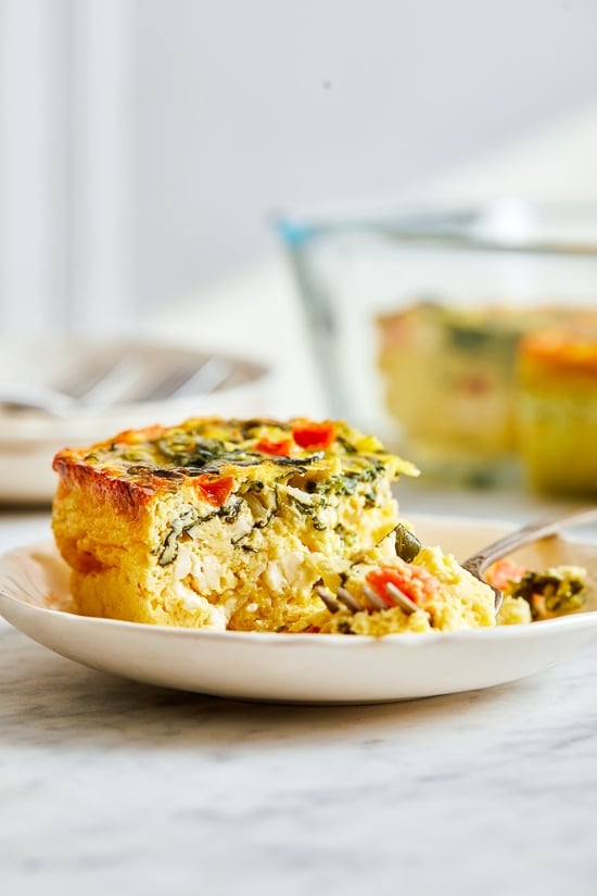 This easy Breakfast Casserole recipe is made with eggs, spinach, tomatoes and Feta cheese and only takes a few minutes to whip up. You can make it ahead of time, so it’s the perfect breakfast egg casserole for Christmas morning or any day!