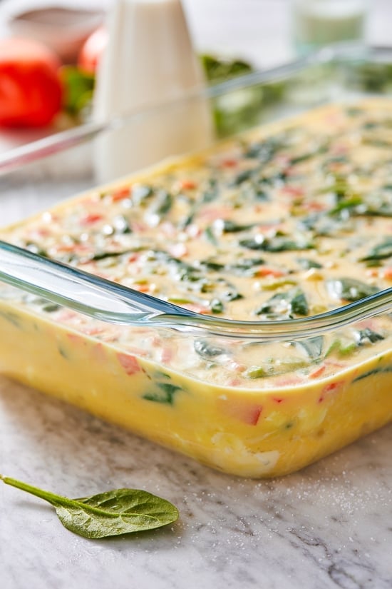 This easy Breakfast Casserole recipe is made with eggs, spinach, tomatoes and Feta cheese and only takes a few minutes to whip up. You can make it ahead of time, so it’s the perfect breakfast egg casserole for Christmas morning or any day!