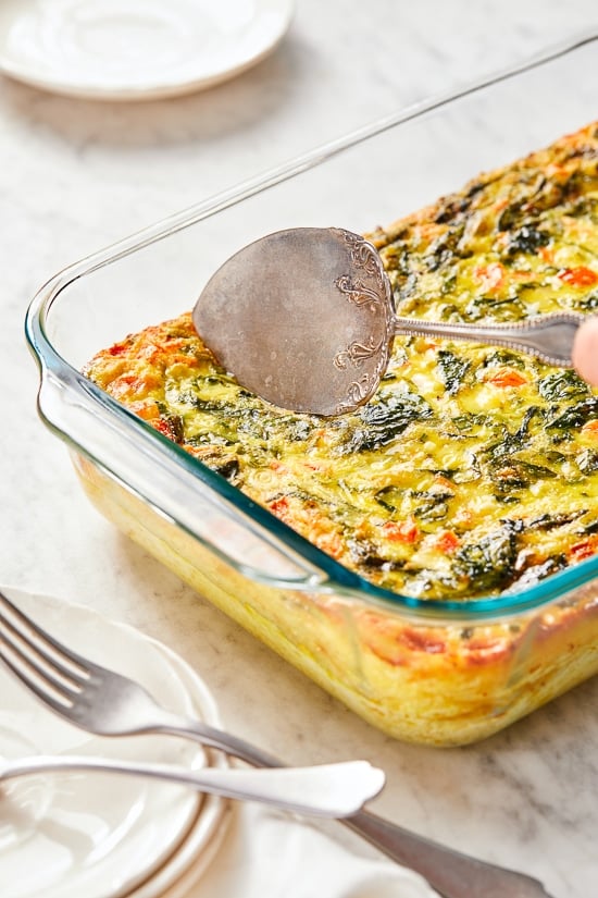 This easy Breakfast Casserole recipe is made with eggs, spinach, tomatoes and Feta cheese and only takes a few minutes to whip up. You can make it ahead of time, so it’s the perfect breakfast egg casserole for Christmas morning or any day!