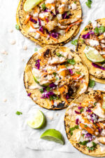 This easy, healthy fish taco recipe is made with cod seasoned with a chili-lime cumin rub topped with slaw – no breading, no frying!