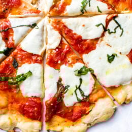 Easy Margherita Pizza made from scratch with my yeast-free, thin crust pizza dough topped with a simple raw tomato sauce, fresh mozzarella cheese, and basil.