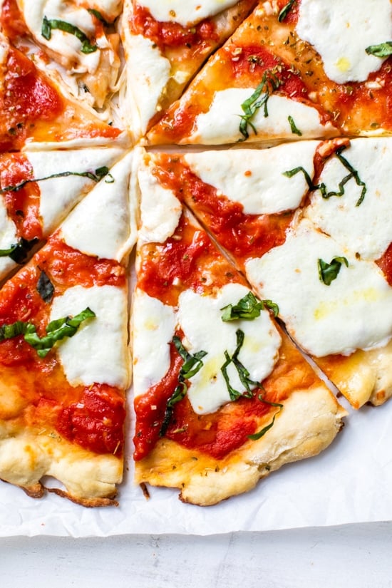 Easy Margherita Pizza made from scratch with my yeast-free, thin crust pizza dough topped with a simple raw tomato sauce, fresh mozzarella cheese, and basil.