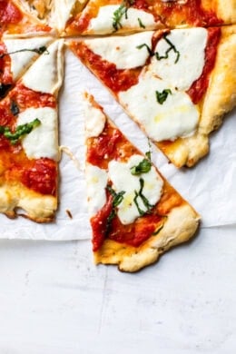 Easy Margherita Pizza made from scratch with my yeast-free, thin crust pizza dough topped with a simple raw tomato sauce, fresh mozzarella cheese, and basil.
