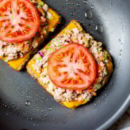 open faced tuna melt with cheddar and tomato in a skillet