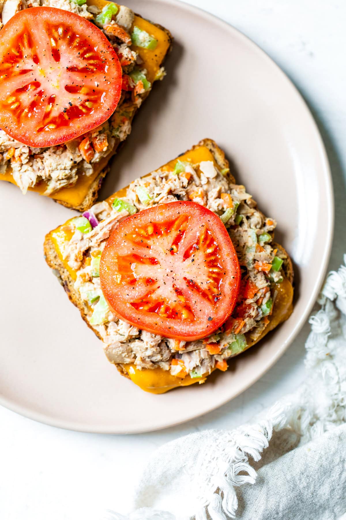 Tuna salad on bread with cheese and tomato