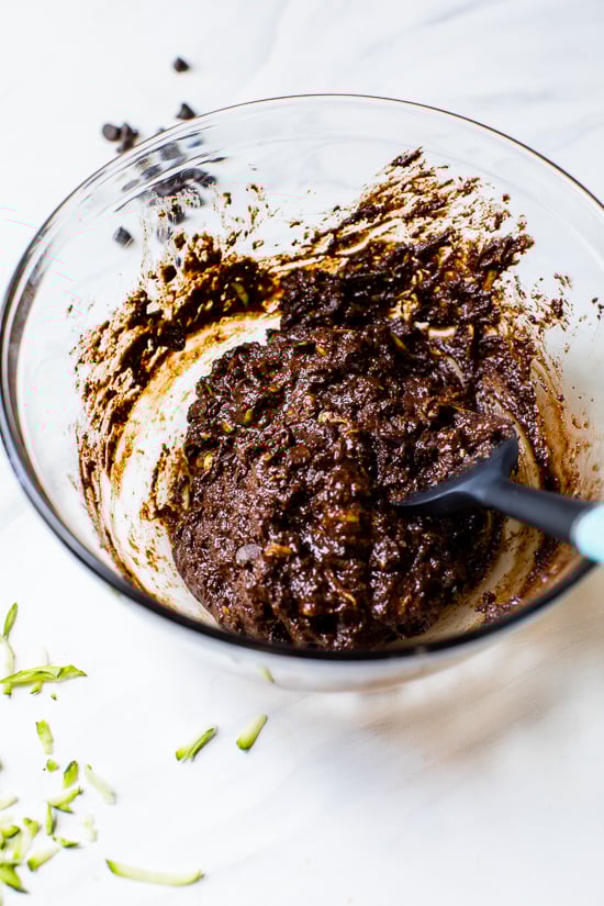 These easy Flourless Zucchini Brownies are made with almond meal, so they're naturally gluten-free. They're moist, fudgy, and so decadent! Zucchini brownie batter in glass mixing bowl with rubber spatula
