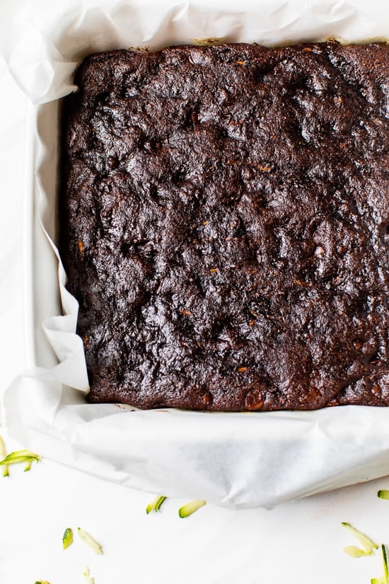 These easy Flourless Zucchini Brownies are made with almond meal, so they're naturally gluten-free. They're moist, fudgy, and so decadent! Overhead view of zucchini brownies in parchment-lined pan