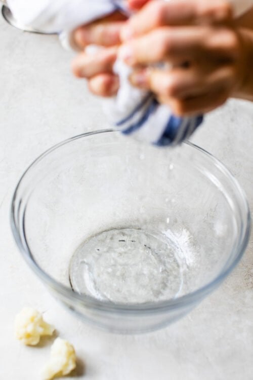 cauliflower in a dish towel and squeeze out as much excess water as possible