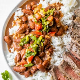 Dominican Beans over rice with aji picante on top and steak on the side.