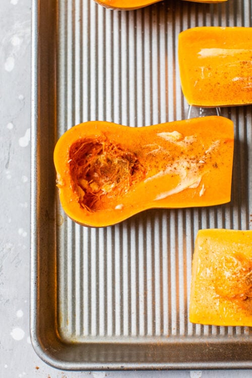 cut open honeynut squash on a sheet pan.