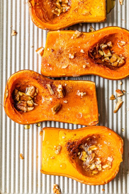 Baked honeynut squash on a sheetpan.