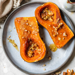 Honeynut squash on a plate with pecans.