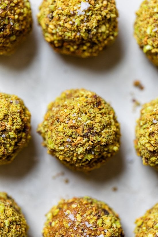Made with cashews, pistachios, dates, pumpkin and spices, these no-bake Pumpkin Pistachio Energy Balls taste like little bites of pumpkin pie. Pumpkin Pistachio Energy Balls on a baking sheet