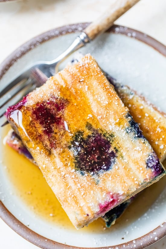stacked sheet pan pancakes with syrup on a plate