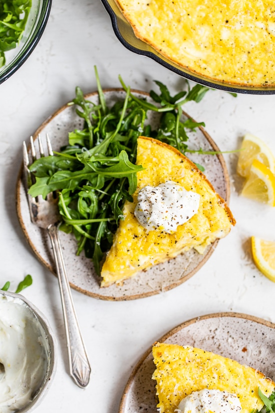 This creamy and delicious Cacio e Pepe Frittata is a fun twist on the Italian classic pasta dish. A protein- packed breakfast, lunch or dinner made with roasted cauliflower, Greek yogurt, eggs, and Parmesan served with a dollop of lemony yogurt and arugula salad.