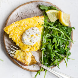 This creamy and delicious Cacio e Pepe Frittata is a fun twist on the Italian classic pasta dish. A protein- packed breakfast, lunch or dinner made with roasted cauliflower, Greek yogurt, eggs, and Parmesan served with a dollop of lemony yogurt and arugula salad.