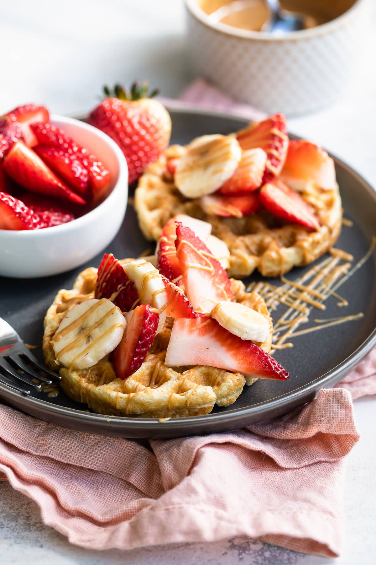 Waffles with strawberries, peanut butter and bananas.