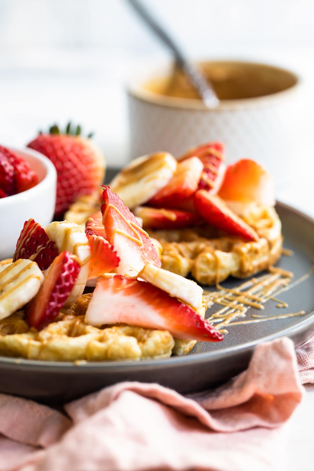 Waffles with strawberries, peanut butter and bananas.
