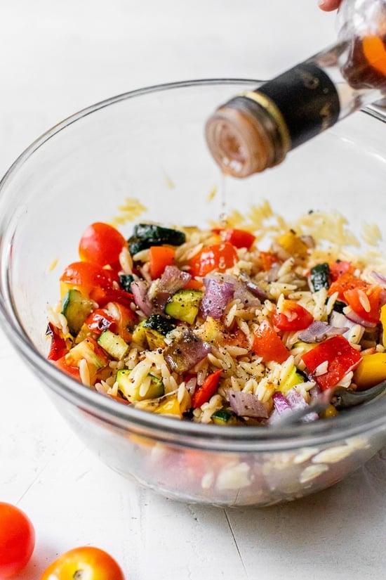 adding red wine vinegar to pasta salad
