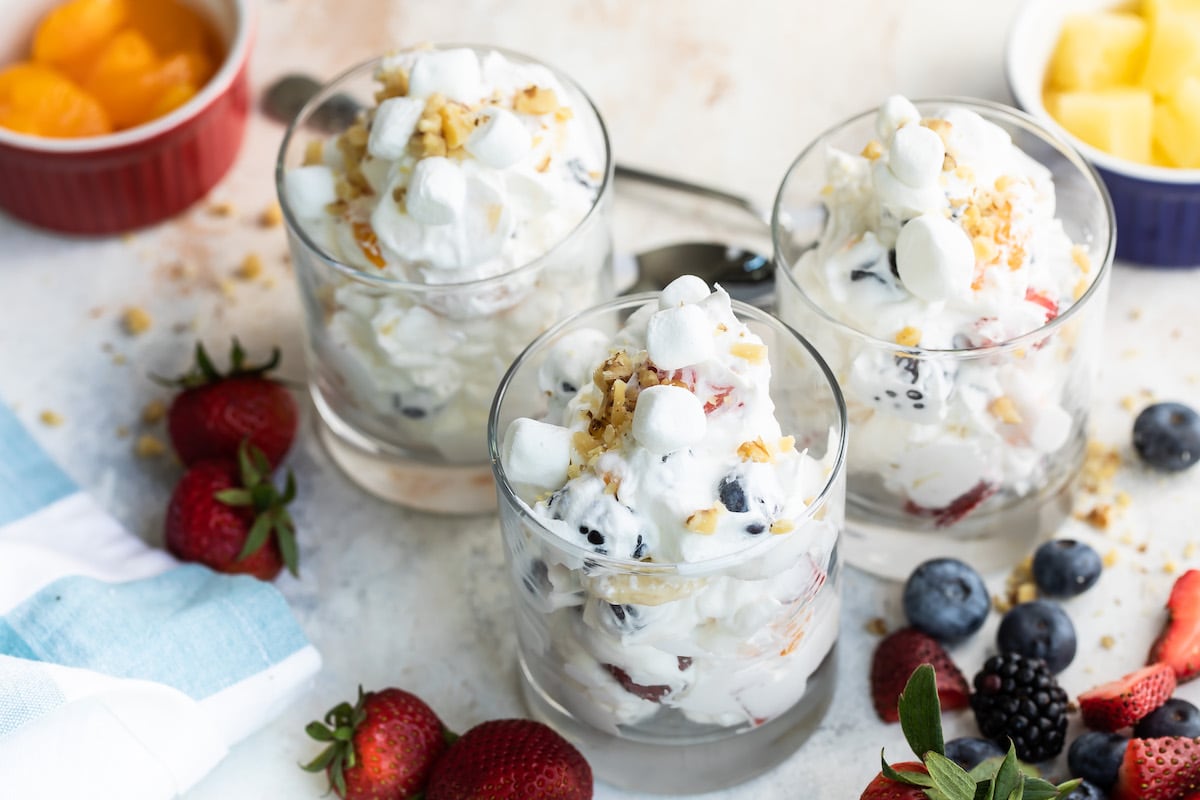 Three glasses of Ambrosia salad with toppings.