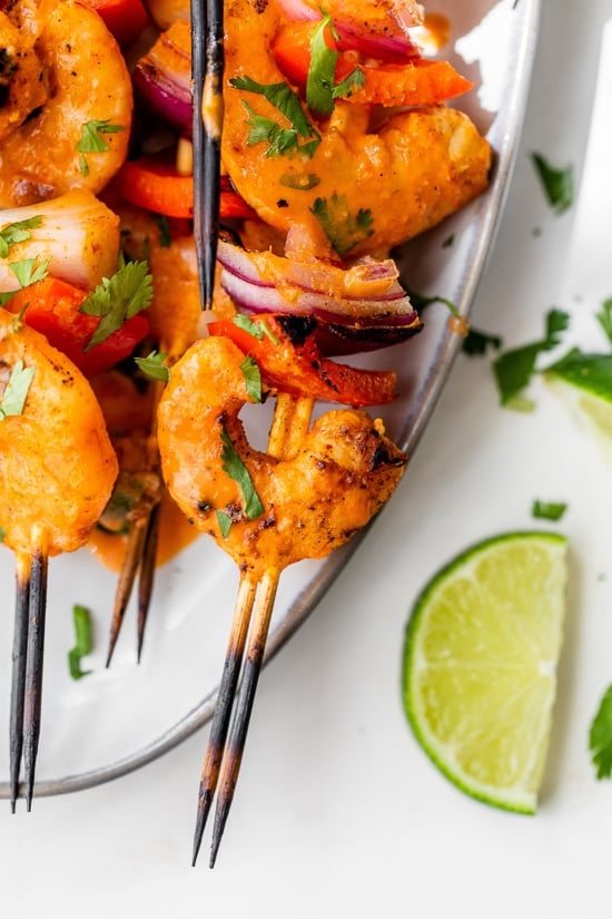 Shrimp Skewers with onions, bell pepper and lime wedges