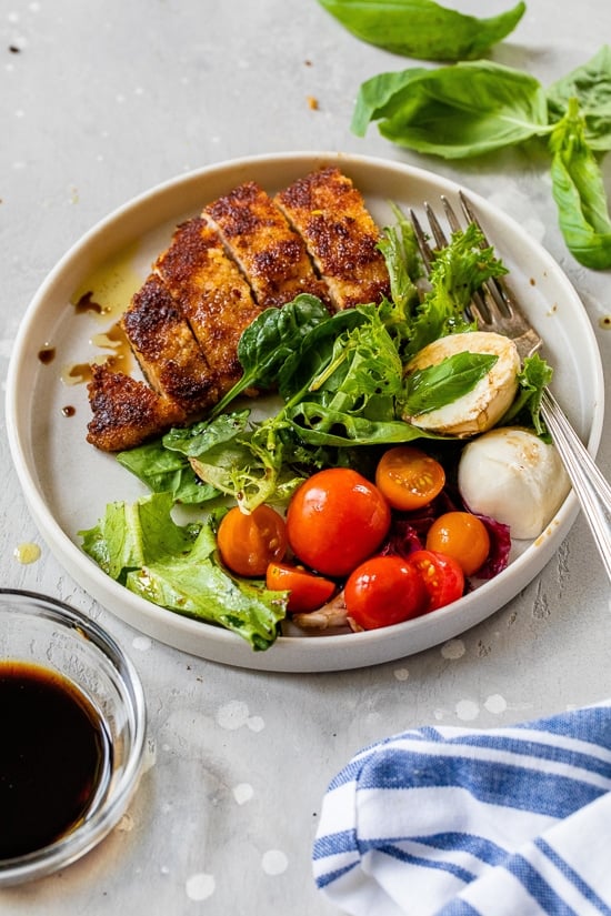 Chicken cutlets with caprese salad.