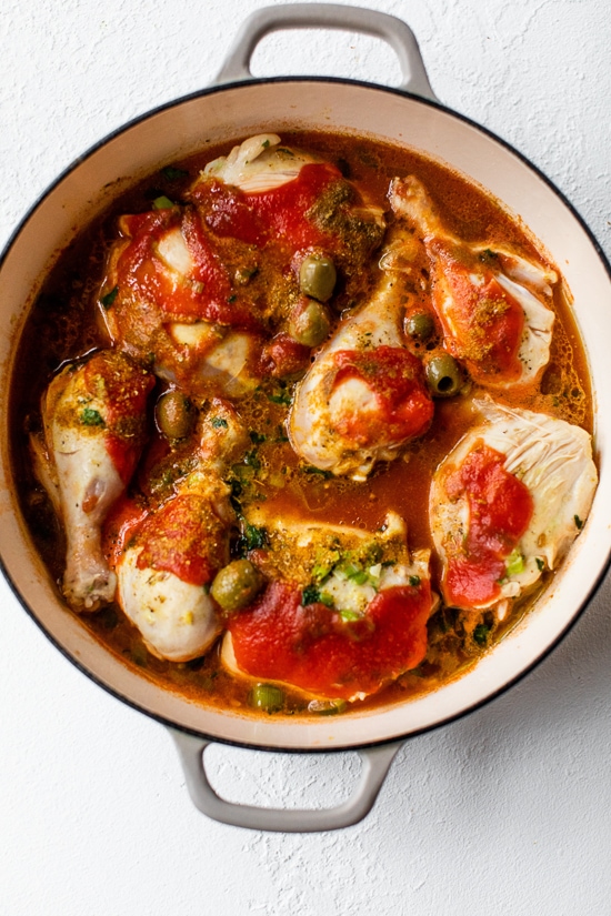 simmering chicken stew with tomato and olives