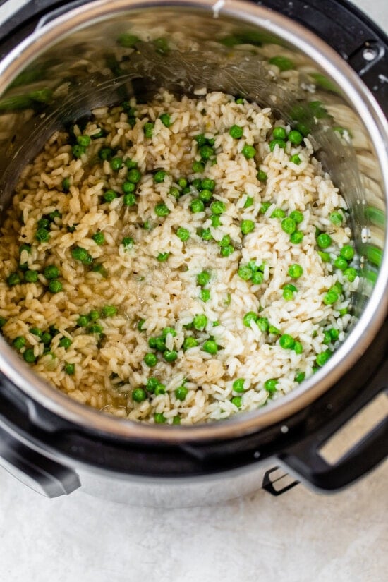 This Instant Pot Risotto recipe is the quickest, easiest way to make risotto. Perfectly creamy every time and it's ready in just 20 minutes. Risotto and peas in an instant pot