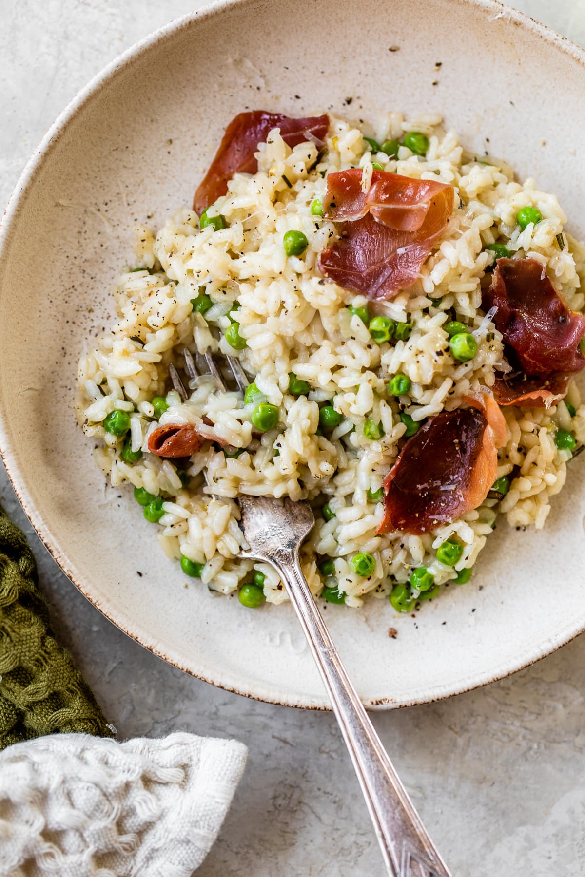 This Instant Pot Risotto recipe is the quickest, easiest way to make risotto. Perfectly creamy every time and it's ready in just 20 minutes. A bowl of risotto with peas and prosciutto