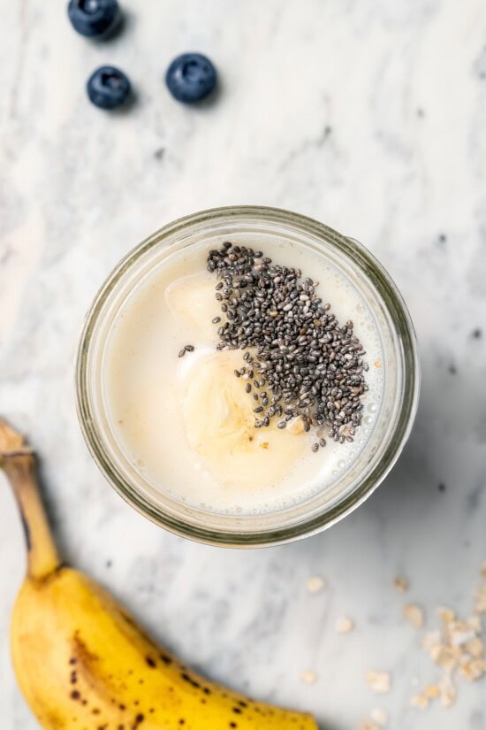 Overnight oats are the easiest way to work a healthy breakfast into your morning! No cooking required, they're a hearty breakfast packed with fiber, vitamins, and nutrients. Overhead view of chia seeds added to jar of overnight oats