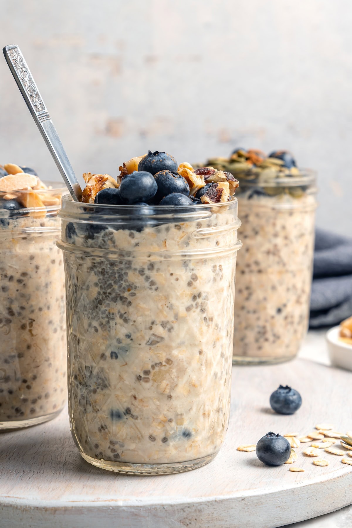 Overnight oats are the easiest way to work a healthy breakfast into your morning! No cooking required, they're a hearty breakfast packed with fiber, vitamins, and nutrients. 3 jars of overnight oats topped with blueberries and walnuts
