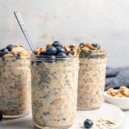 3 jars of overnight oats topped with blueberries and walnuts