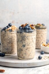 3 jars of overnight oats topped with blueberries and walnuts