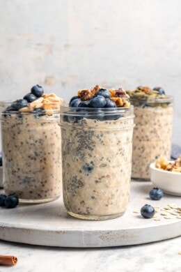 3 jars of overnight oats topped with blueberries and walnuts