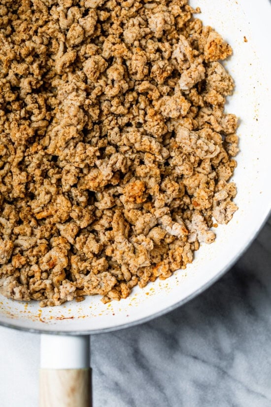 Cook the ground turkey in a skillet.