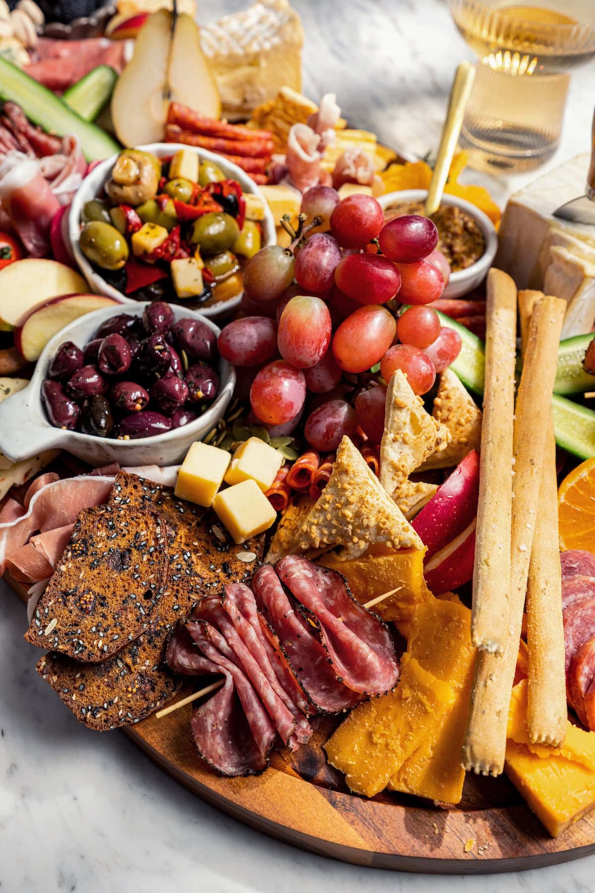 Your ultimate guide to creating a charcuterie and cheese board! I'll show you how to choose and arrange everything for a beautiful spread. Charcuterie board with cheese, meat, fruit, olives, and more.