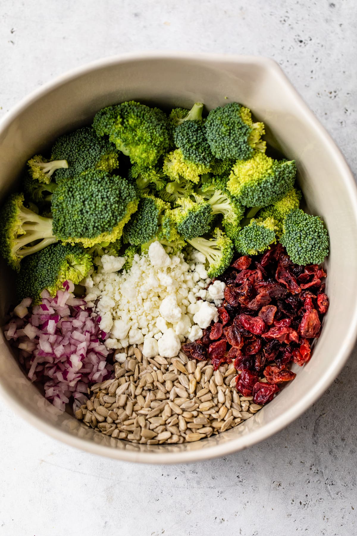 broccoli, bacon, sunflower seeds and goat cheese in a bowl