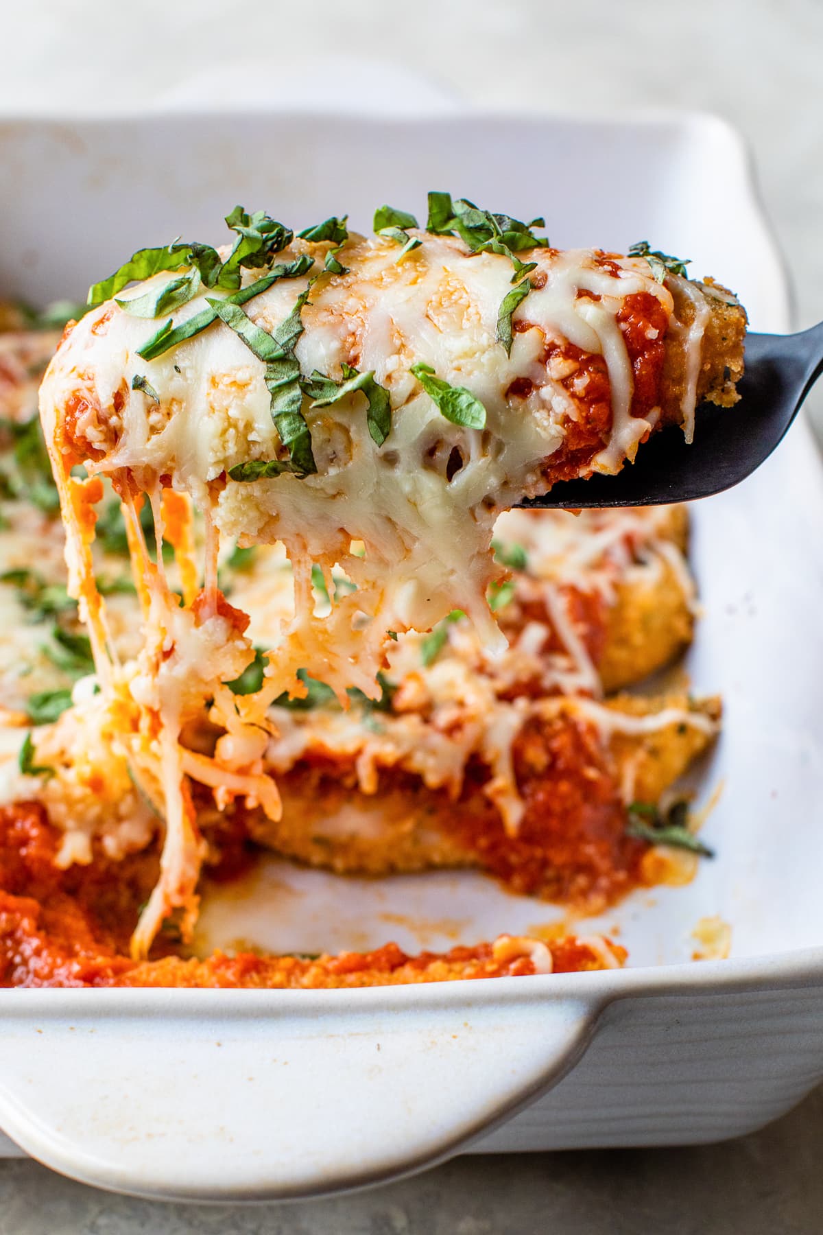 Quick and easy to prepare, this Baked Chicken Tenderloin Parmesan is a family-friendly weeknight dish, prepared with just a few ingredients. Chicken Tenders Parmesan on a spatula