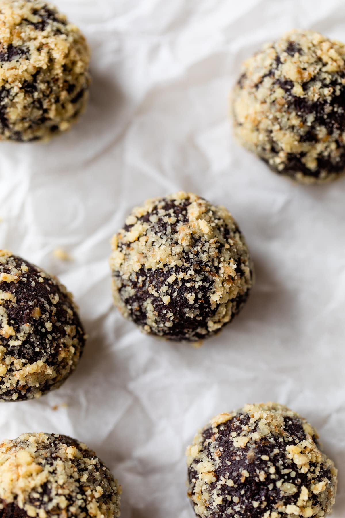 Made with Medjool dates, pumpkin, and cocoa powder, these Chocolate Date Balls taste just like a brownie! No bake & easy! Overhead view of date energy balls on parchment paper