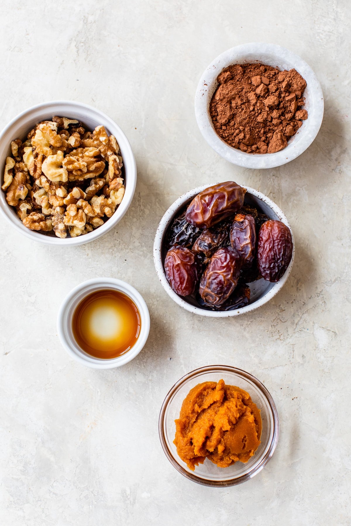 Made with Medjool dates, pumpkin, and cocoa powder, these Chocolate Date Balls taste just like a brownie! No bake & easy! Overhead view of ingredients needed for chocolate balls
