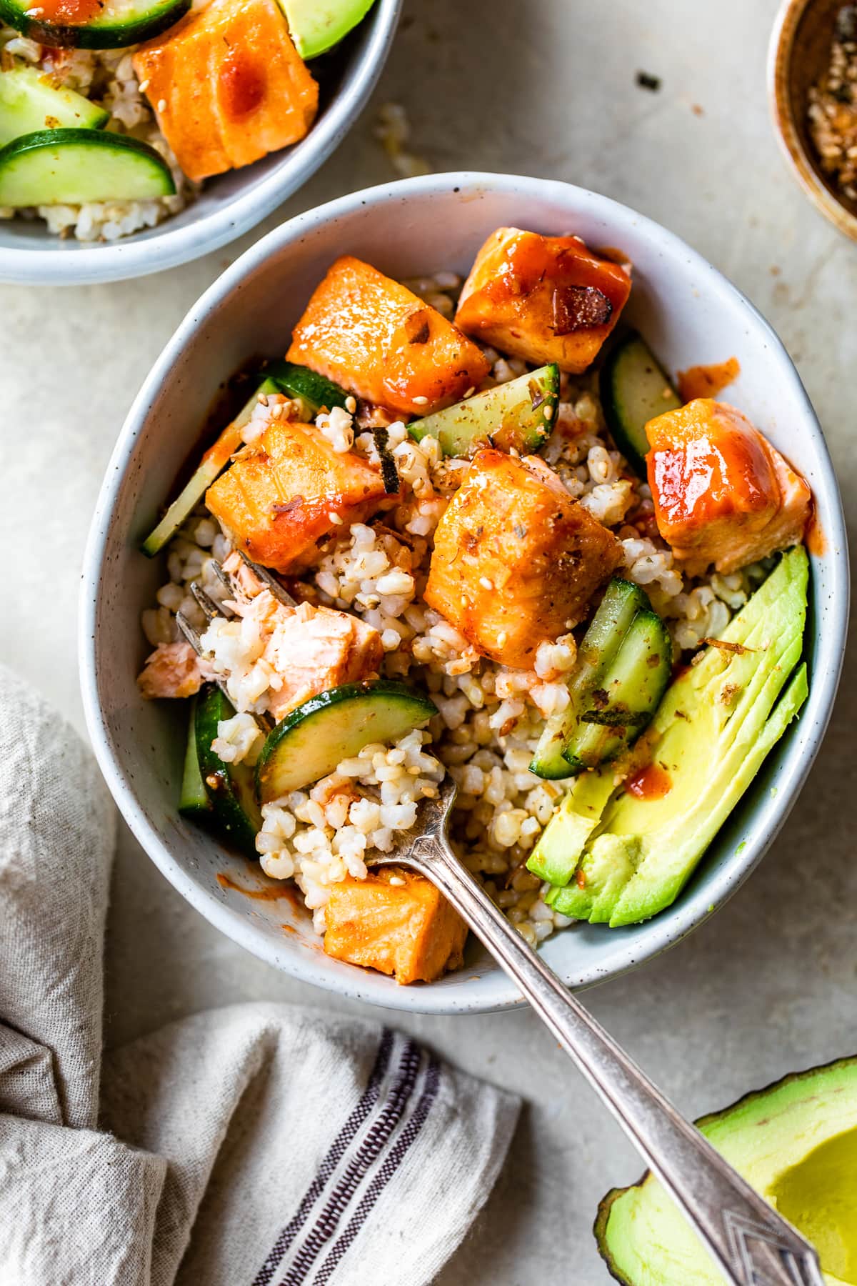 Honey Sriracha Roasted Salmon Bowls with a fork