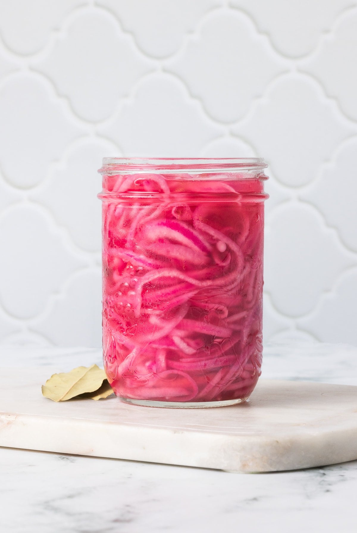These easy pickled red onions are add a tangy, slightly sweet, and crunchy element to steaks, sandwiches, tacos, burrito bowls and more! Pickled Red Onions in mason jar