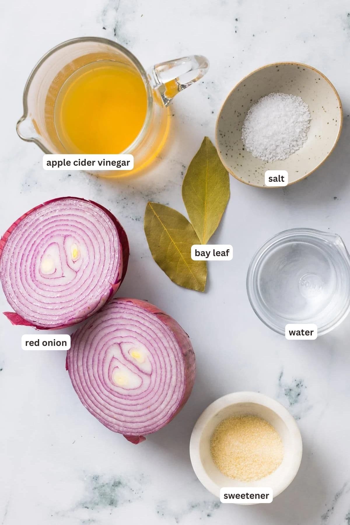 These easy pickled red onions are add a tangy, slightly sweet, and crunchy element to steaks, sandwiches, tacos, burrito bowls and more! Ingredients for pickled red onions on a marble counter.