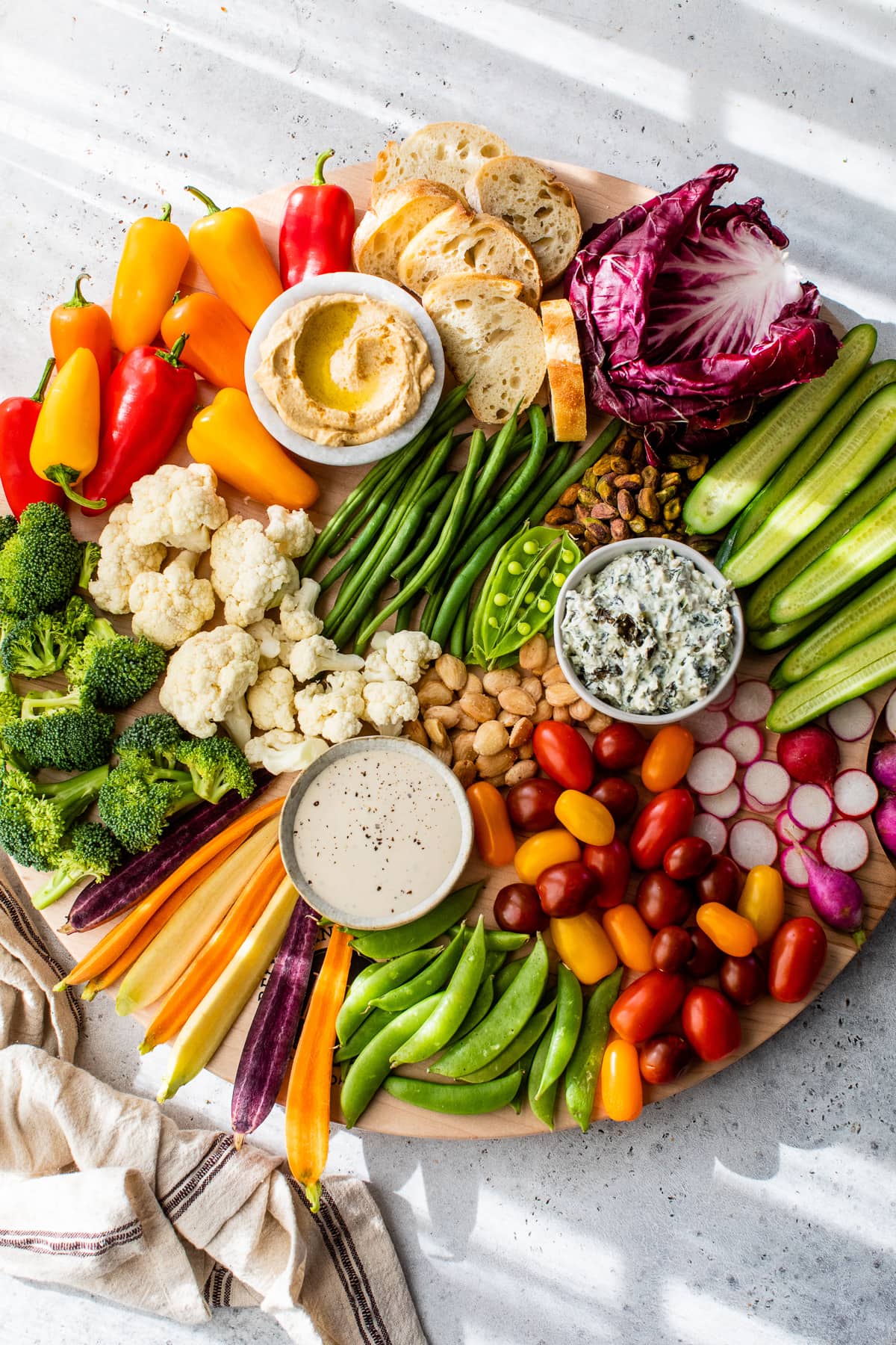 Overhead view of veggie tray with 3 bowls of dip