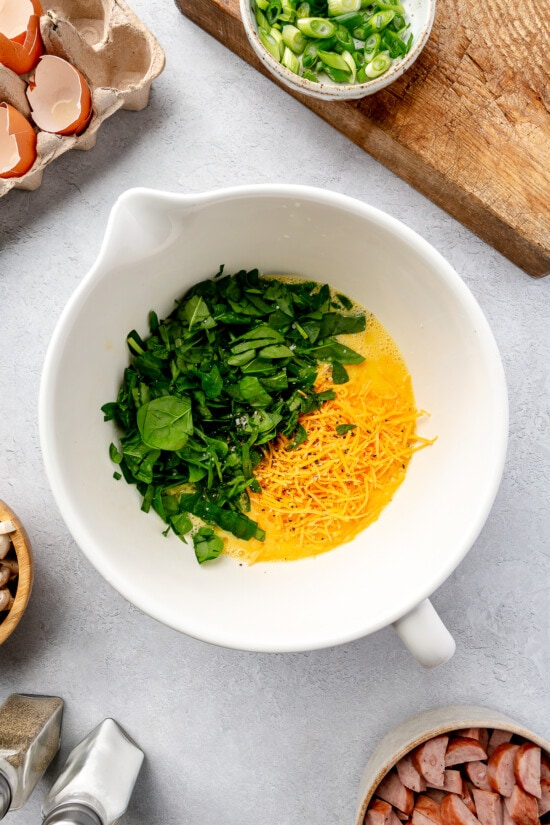 eggs, spinach and cheese in a bowl.