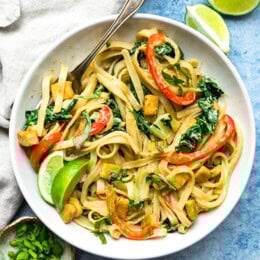 Green Curry Noodles in a bowl with limes.