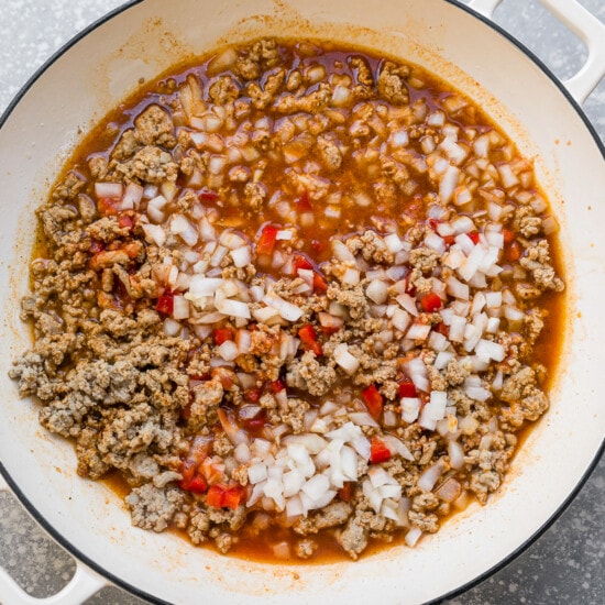 Add seasoning, onions, bell pepper and tomato sauce