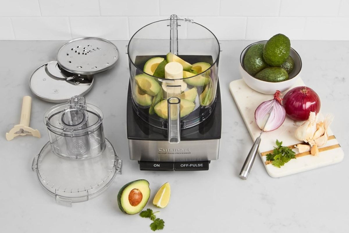Cuisinart food processor next to accessories and avocados